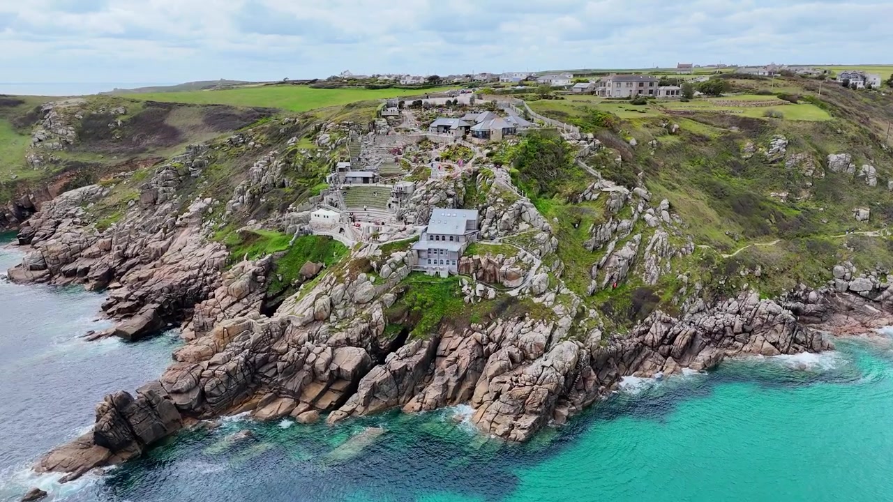 Kaunista ilmakuvaa Minack-teatterista, joka kohoaa dramaattisilla kallioilla turkoosien vesien yllä Cornwallin upealla kallioisella rannikolla.