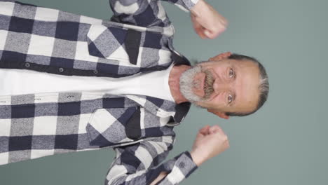 vertical video of old man clapping excitedly to camera.