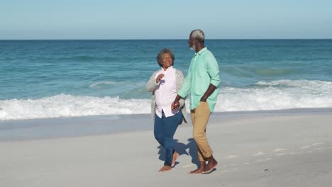 pareja de ancianos caminando a lo largo de la playa