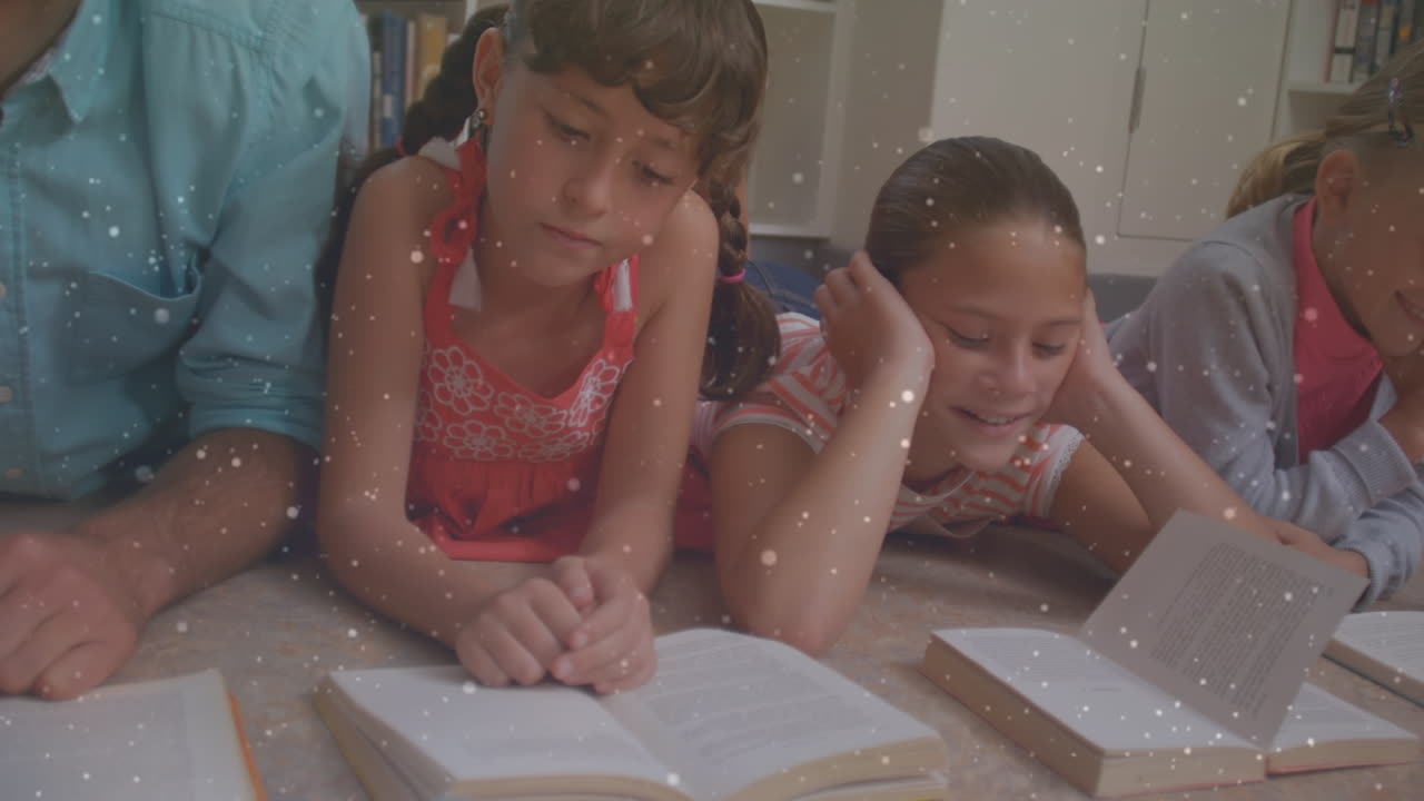 animación de partículas sobre hermanos caucásicos leyendo libros mientras están tendidos en el suelo