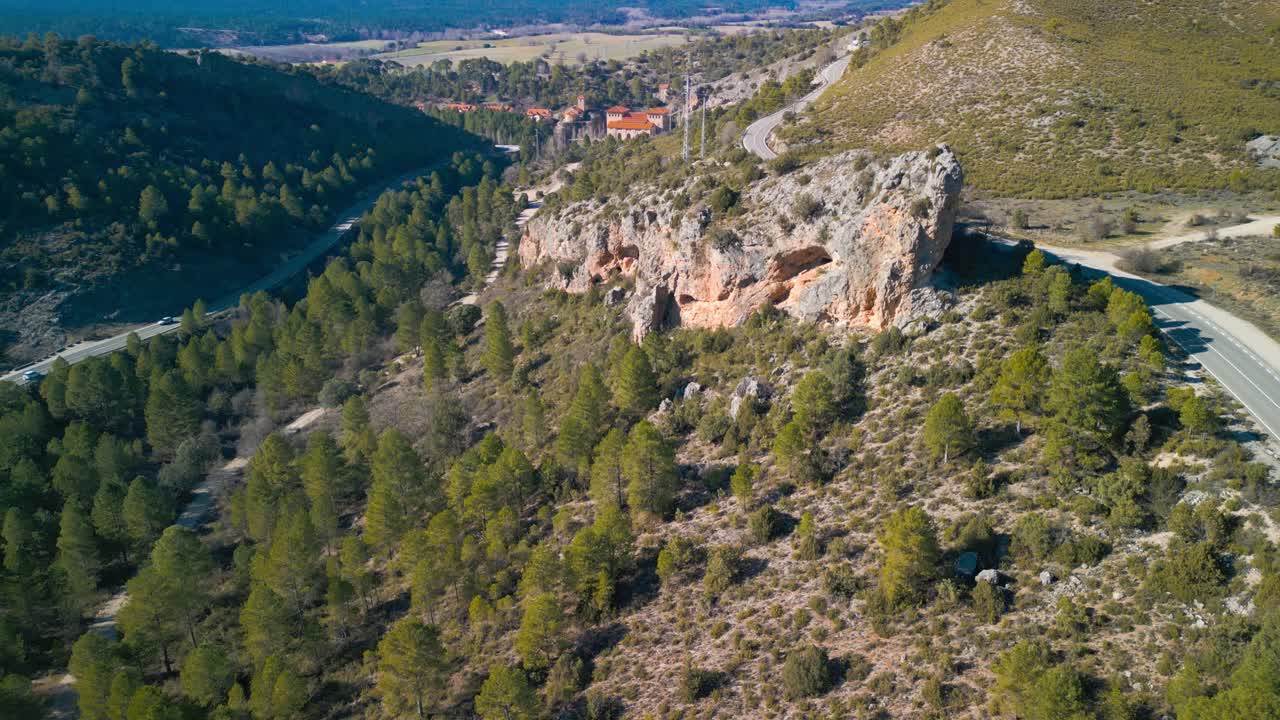 Vista aerea di una valle di montagna con foresta, strade tortuose e formazioni rocciose