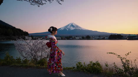 woman in kimono with mount fuji and cherry blossoms at sunset