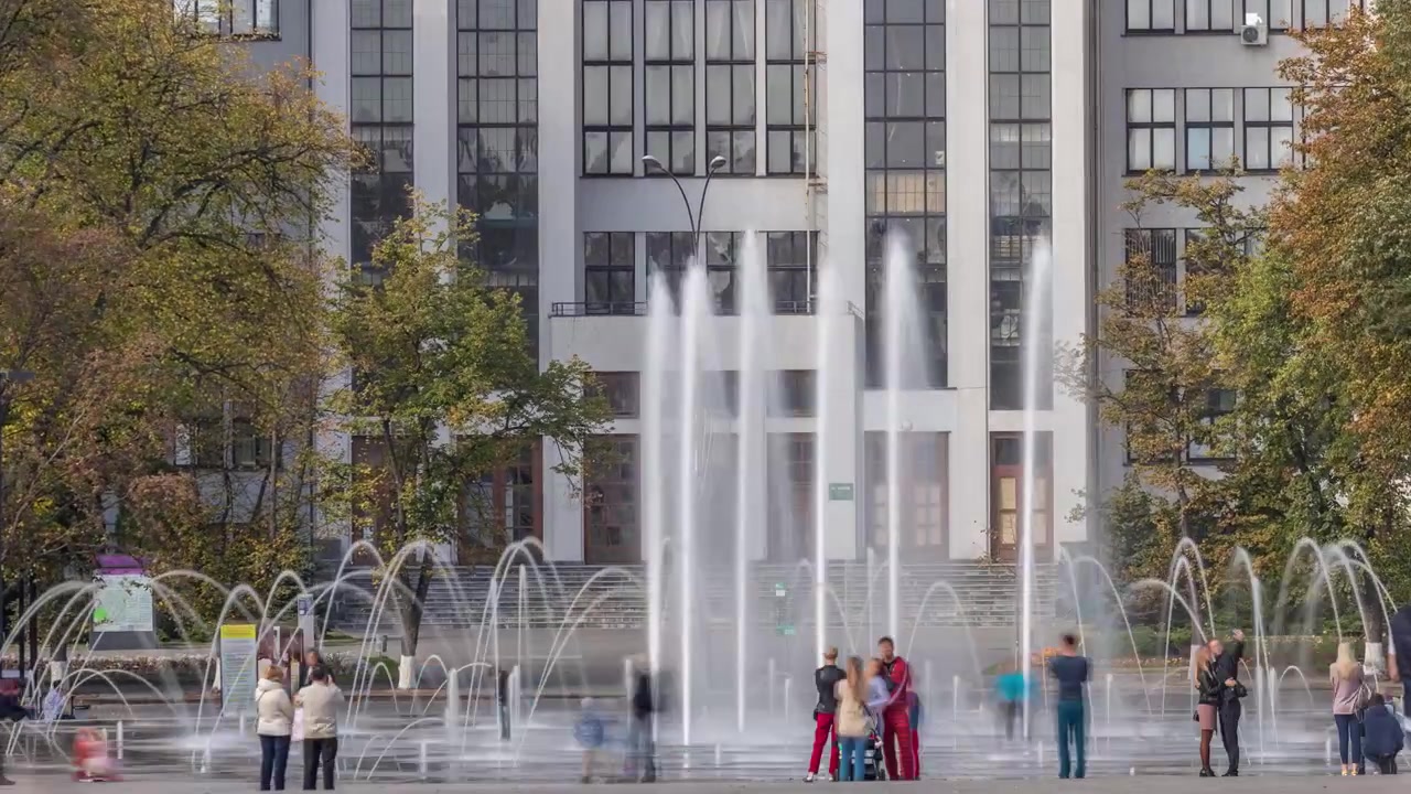 Edificio Gosprom en la Plaza de la Libertad con una nueva fuente seca y gente caminando en el parque en la ciudad de Járkov en timelapse, Ucrania. Vista de cerca