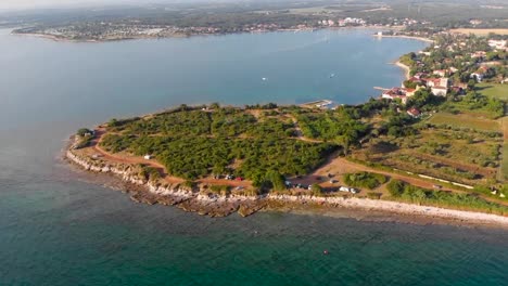 Flying-towards-a-small-bay-dotted-with-boats-and-surrounded-by-houses-and-trees