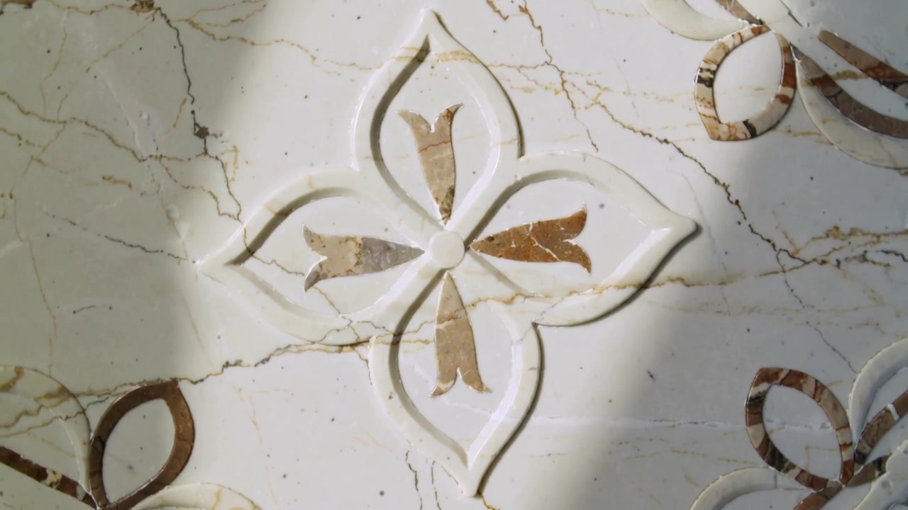 Entering light shifting shadow across marble flower in hall, camera panning revealing ring inlays