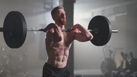 slow motion: male powerlifter preparing for training in gym. screaming man lifting weights