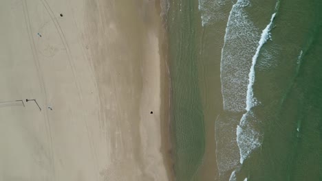 4K-Isolated-top-aerial-view-of-a-vacant-beach-with-a-few-people---Bat-Yam-Israel