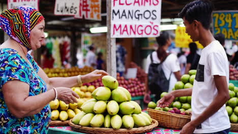 people buying mangoes at a market
