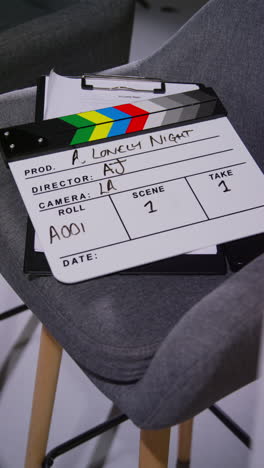 video verticale di primo piano di film clapperboard o ardesia con dettagli di produzione e sceneggiatura girare film o video in studio 1