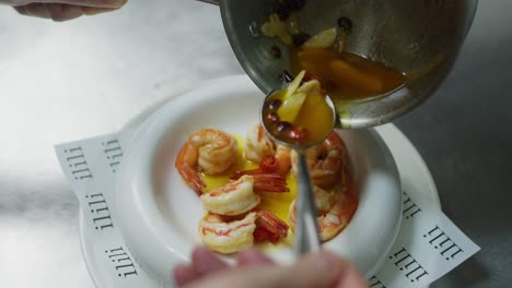 Chef-pouring-olive-oil-over-Mediterranean-fresh-seafood-shrimp-soup,-traditional-healthy-dish