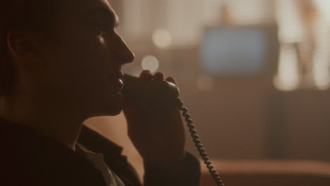 young man talking on vintage phone in living room filled with hazy warm light