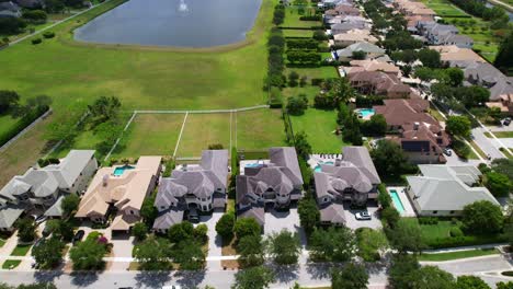 aerial: west palm beach residential area with a pond during the day in florida, usa, dolly in drone shot