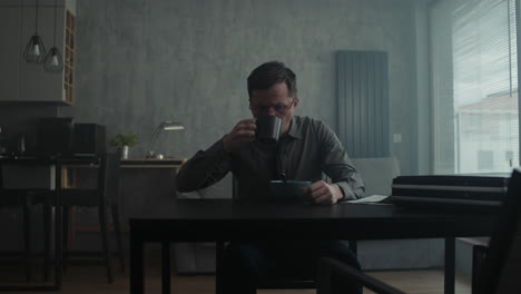 a sad man in a shirt slowly eats breakfast