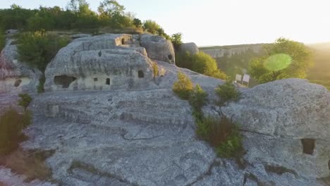 antiguas viviendas rupestres en la ladera de una montaña al amanecer o al atardecer
