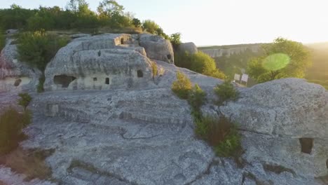 ancient cave dwellings on a mountainside at sunrise/sunset