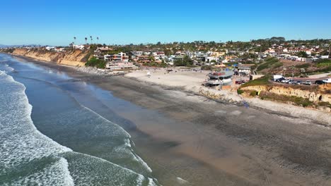 Luftaufnahme,-Die-Sich-Von-Rechts-Nach-Links-Von-Wohnhäusern-Und-Hotels-Entlang-Des-Moonlight-Beach-In-Encinitas,-Kalifornien,-Den-Usa-Bewegt,-Mit-Wellen,-Die-Am-Strand-Krachen