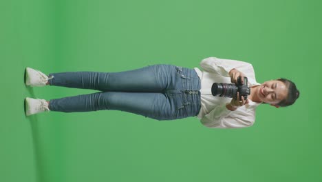 mujer fotógrafa con entusiasmo sosteniendo la cámara