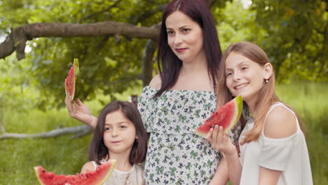 family enjoying watermelon in the park