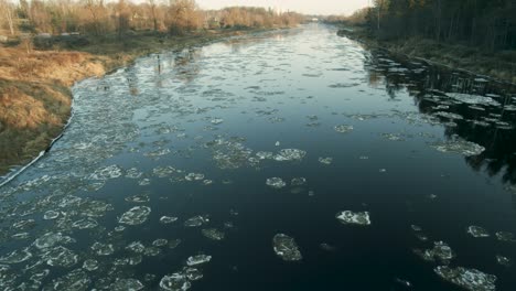 Ice-chunks-going-slow-river-down-stream-in-sunny-winter-day