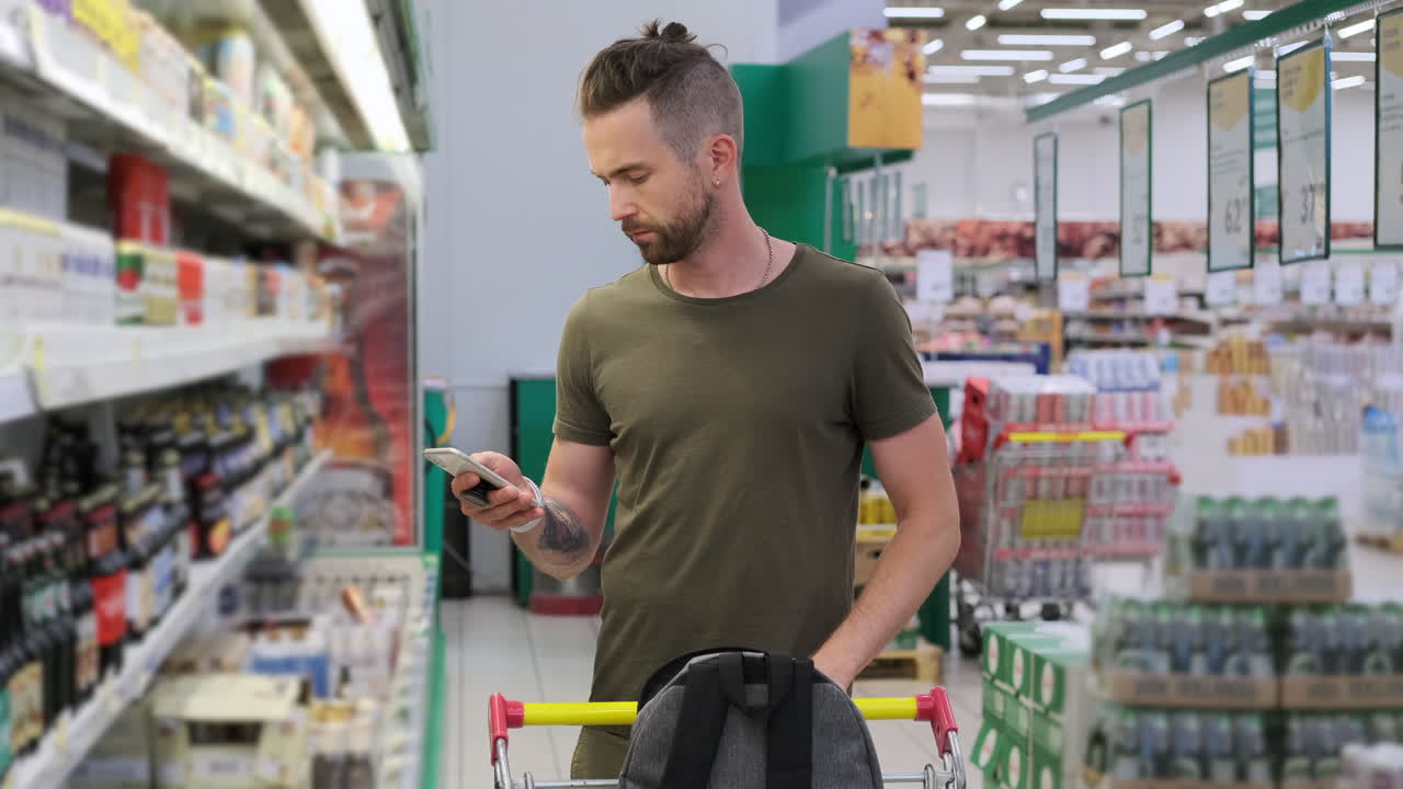 Uomo che usa il telefono in un supermercato