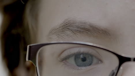 Tight-closeup-on-boy's-blue-eye-and-glasses-and-eye-brow-with-subtle-camera-drift-as-he-is-reading