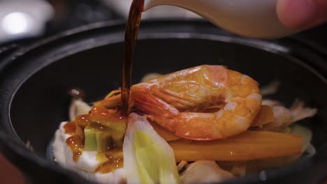 japanese nabe hot pot with sake and seafood, vegetables and tofu