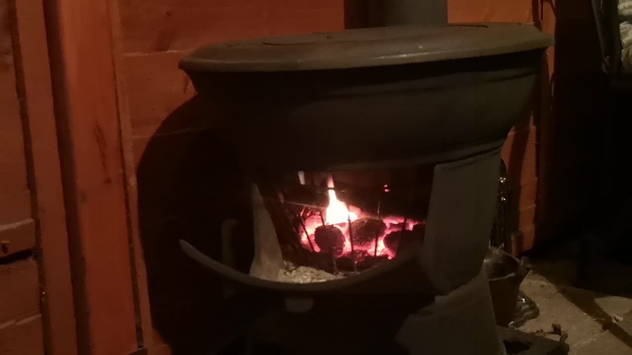 야외 나무 오두막 주방에서 뜨거운 타오르는 주철 장작 난로
