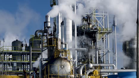 steel pipe and tank installation of the large chemical plant with smoking chimneys polluting the air