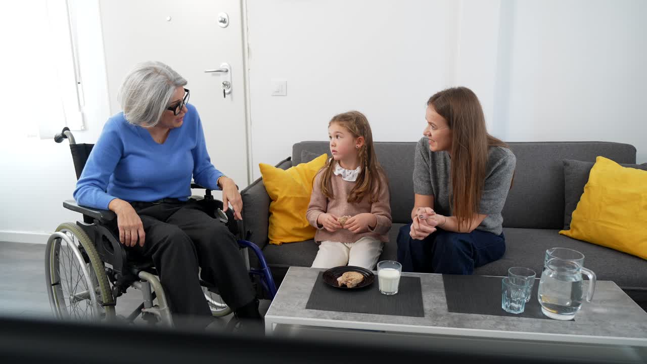 Tre generazioni di donne che parlano in un soggiorno
