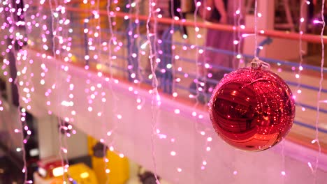 luces de navidad rosas y ornamento rojo en un centro comercial