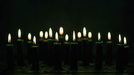 a mesmerizing display of flickering candlelight: a serene atmosphere created by multiple illuminated candles in a darkened setting