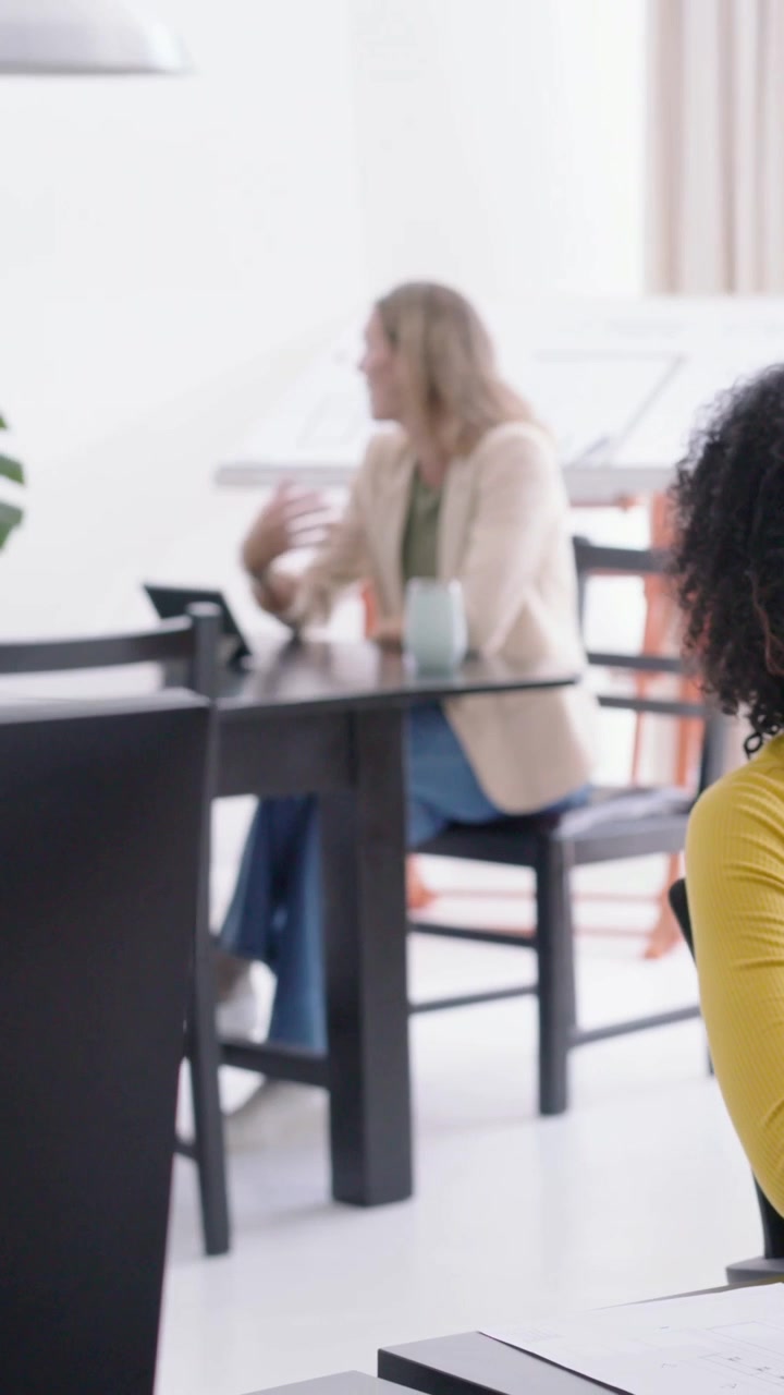 Vertical video: Reacting to incoming call, woman wearing beige blazer tapping tablet at office
