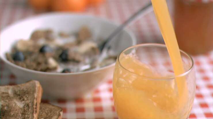Bicchiere di succo d'arancia in super slow motion che viene riempito