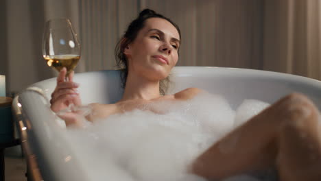 Señora-Encantadora-Sosteniendo-Una-Copa-De-Vino-Poniendo-Un-Baño-De-Burbujas.-Chica-De-Spa-Disfrutando-Del-Alcohol