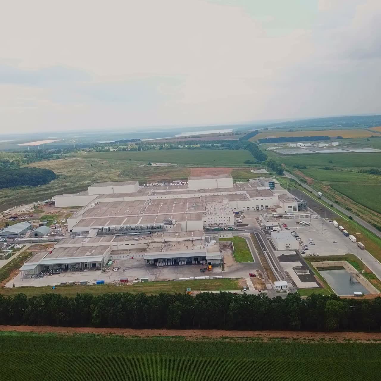 territory of the woodworking plant from above on the background of the countryside. Aerial view