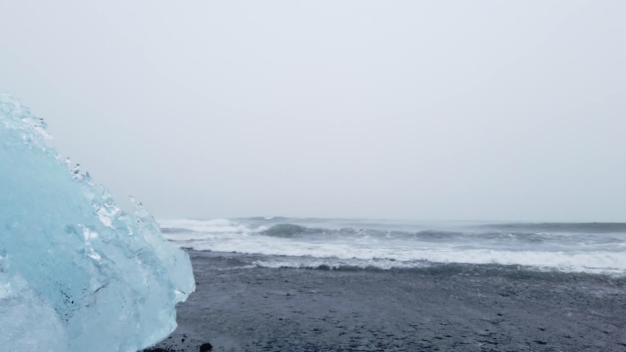 해변에서 충돌하는 얼음과 바다 파도의 총을 닫습니다