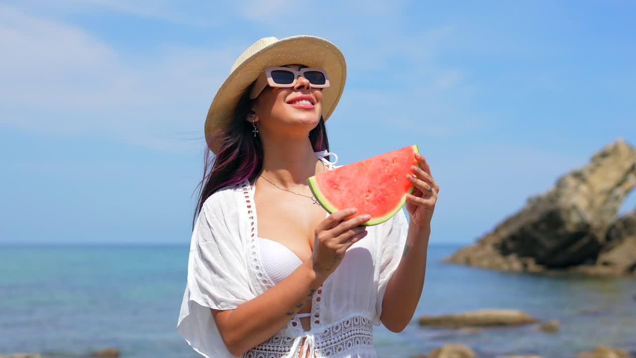 Mujer disfrutando de una sandía en la playa
