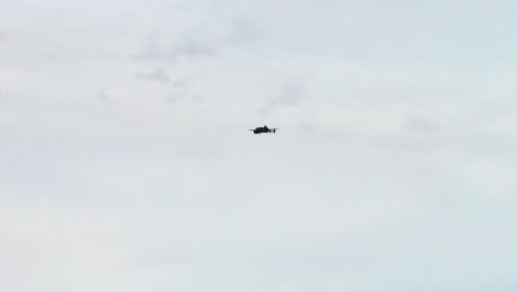 unmanned drone silhouette flying against overcast cloudy sky, czechia