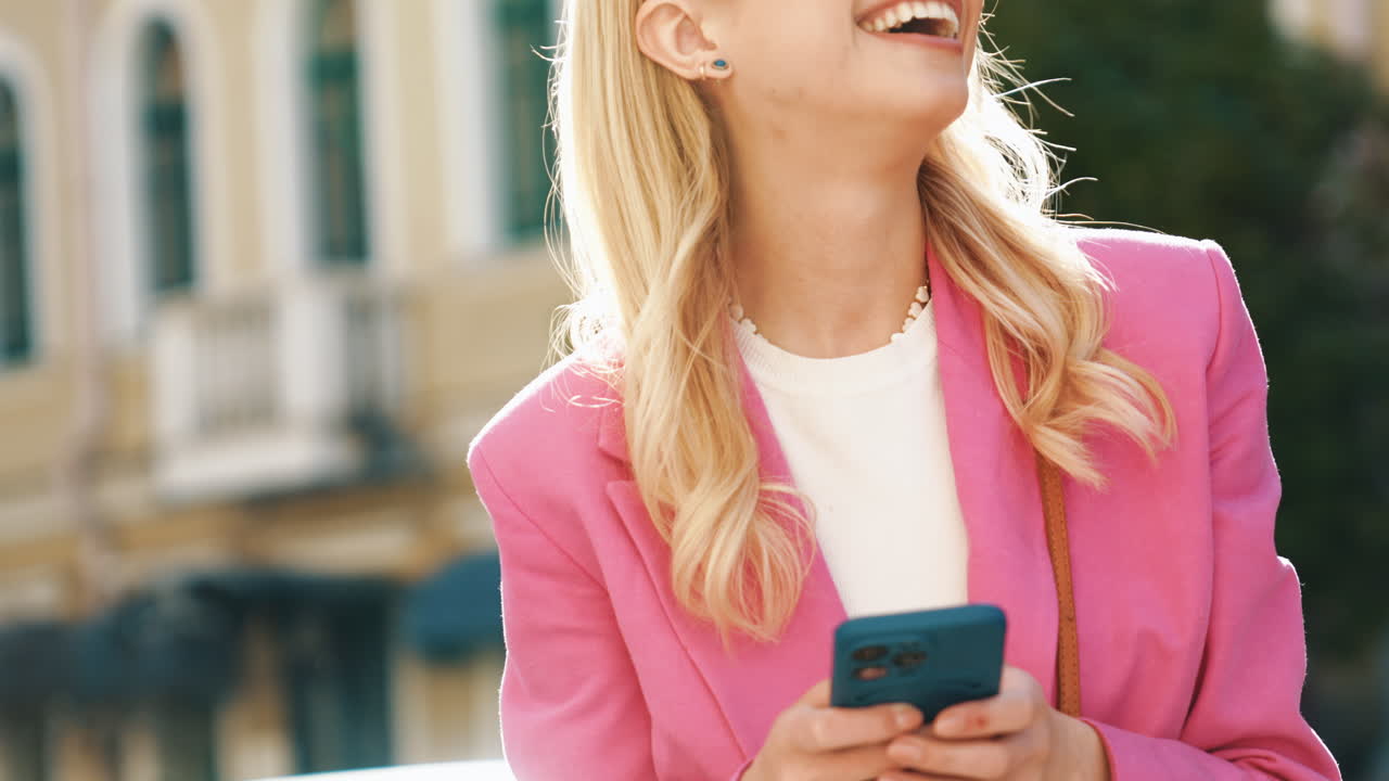 donna sorridente in blazer rosa all'aperto