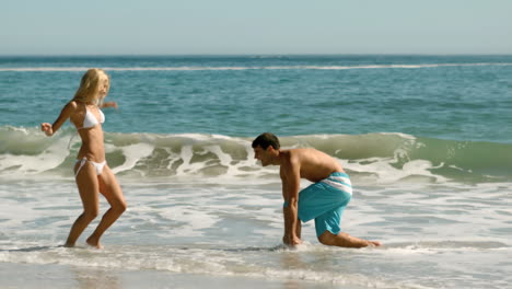 delighted couple playing on the beach