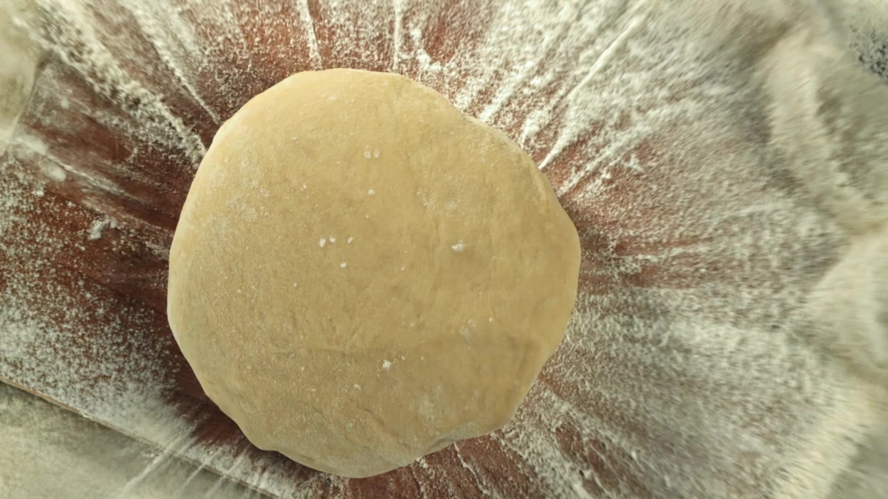 Flour Sprinkled on Fresh Dough Ball on Wooden Board