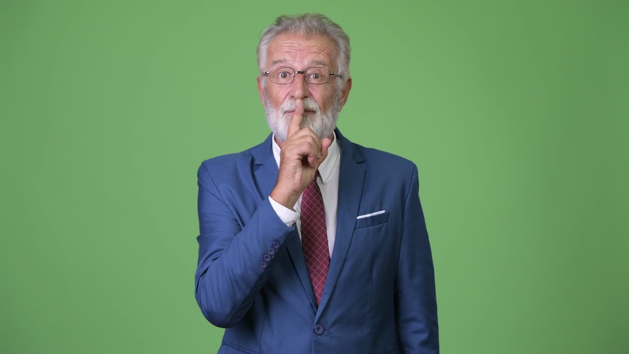Affascinante uomo d'affari anziano con barba su sfondo verde