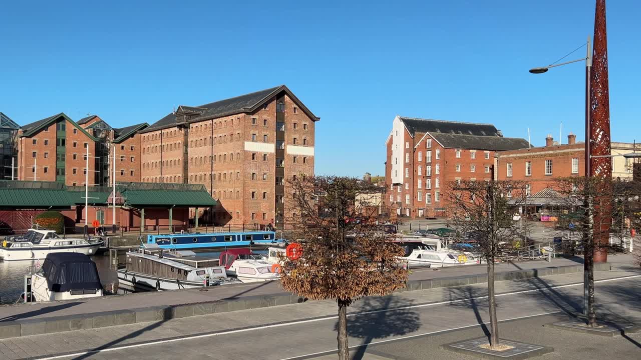 Canal boats moored at Gloucester docks in winter with blue sky