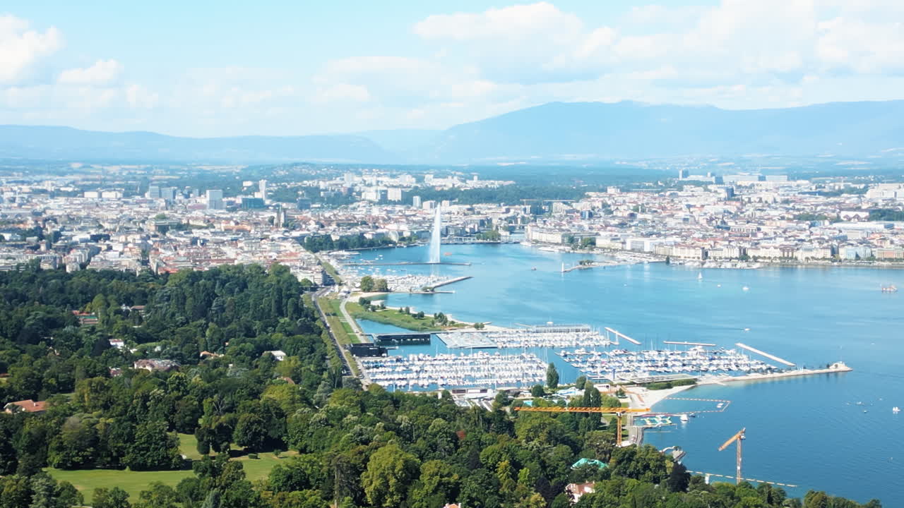 Aerial: Lake Leman and water fountain of Geneva during the day (Rade of Geneva) from Cologny, Switzerland, pan drone shot