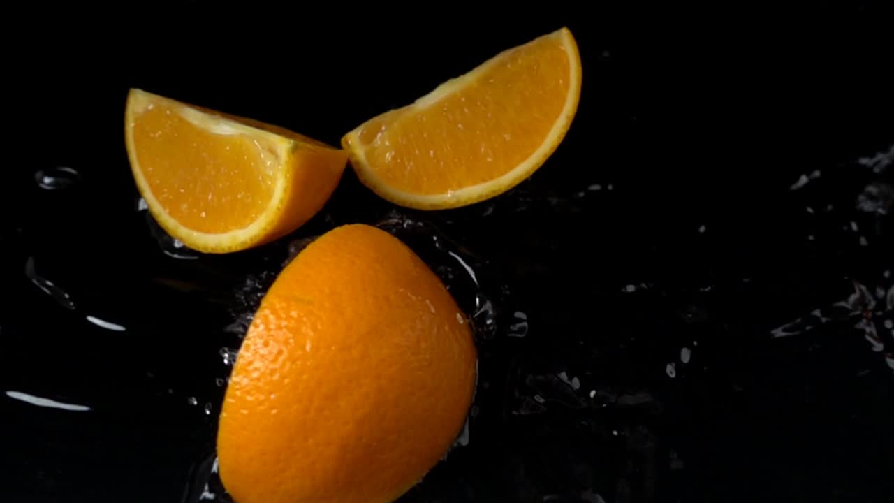 Caduta di arancia in acqua. Slow motion