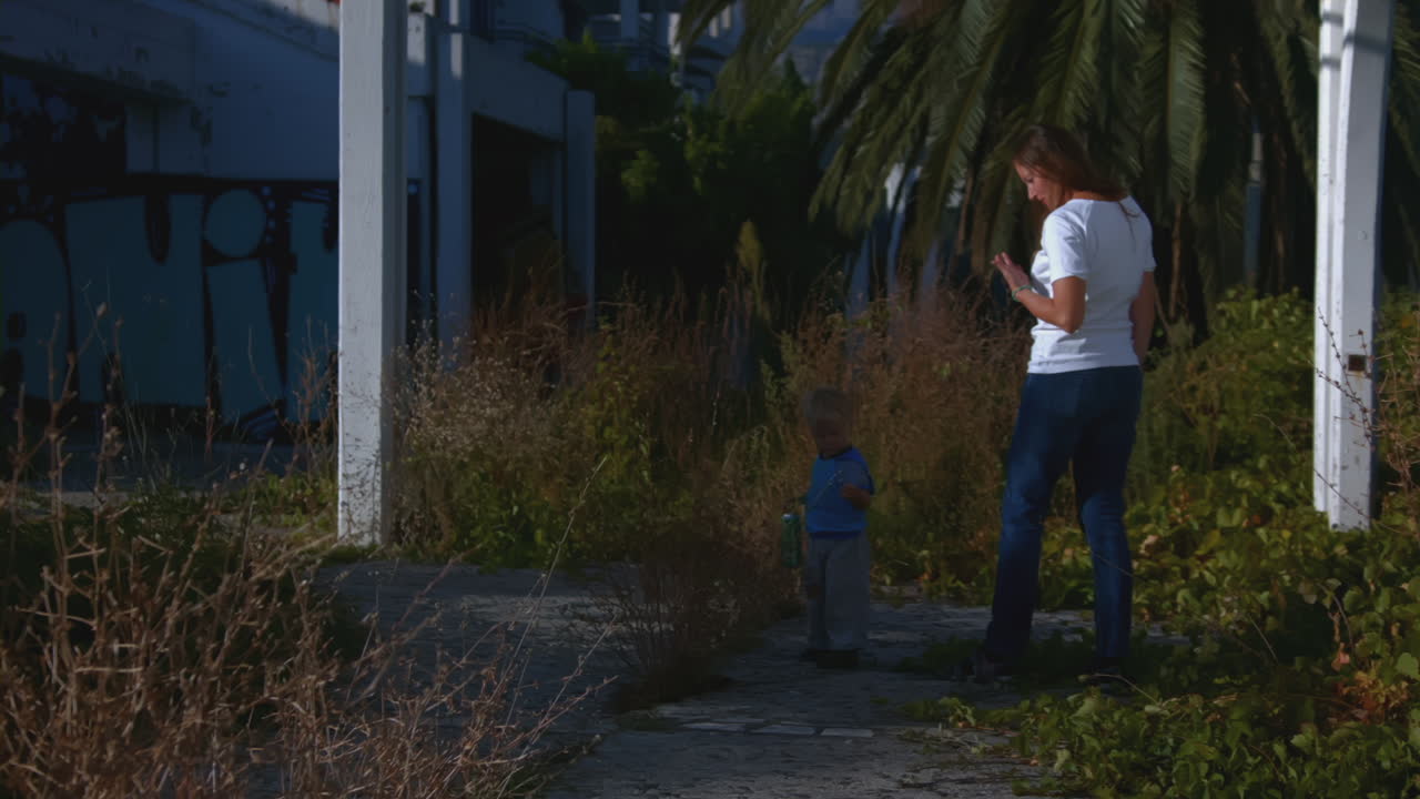 어머니와 아이가 버려진 건물을 탐험하고 있습니다.
