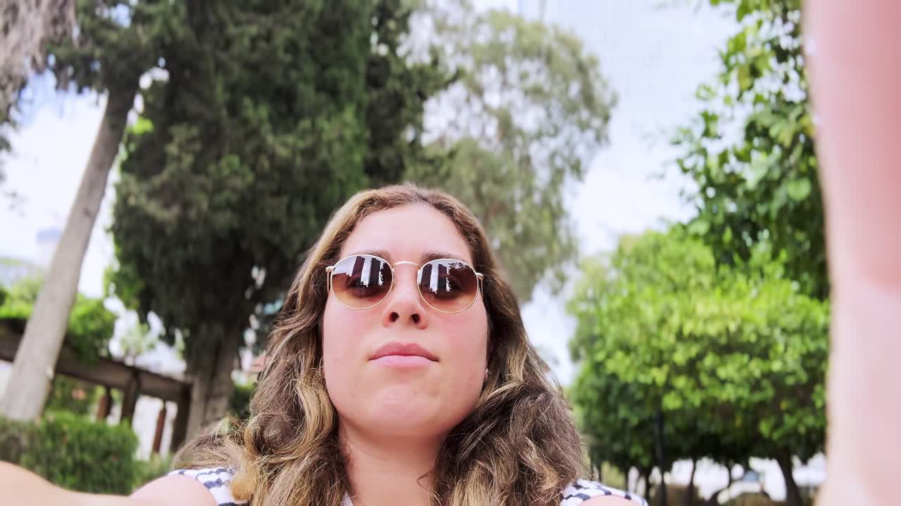 una mujer tomando una selfie en un parque.
