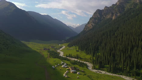 aerial view of a nomadic yurt village in a spectacular mountain valley in kyrgyzstan