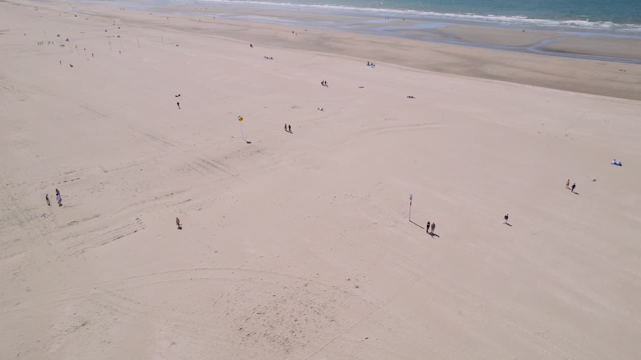 모래 해변에서 화창한 날을 즐기는 분리된 사람들, 공중 전망