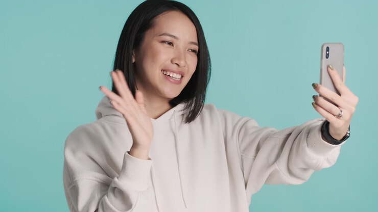 Asian woman having video call on smartphone.
